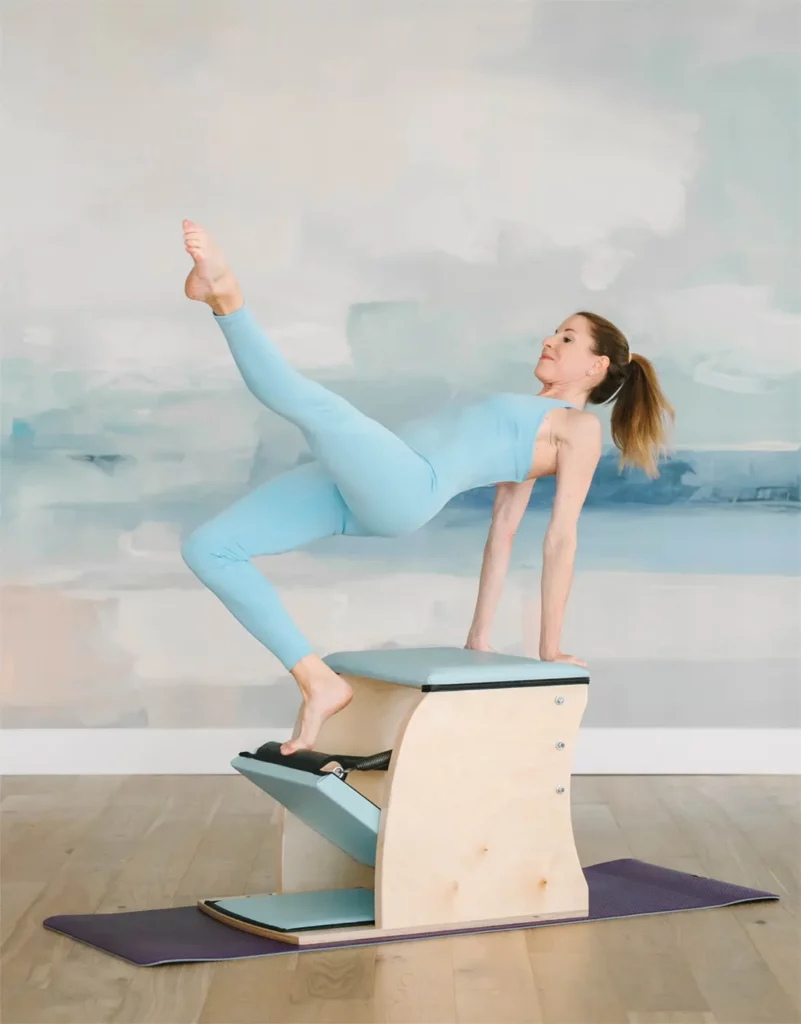 Classical Pilates instructor performing an exercise on the Wunda Chair